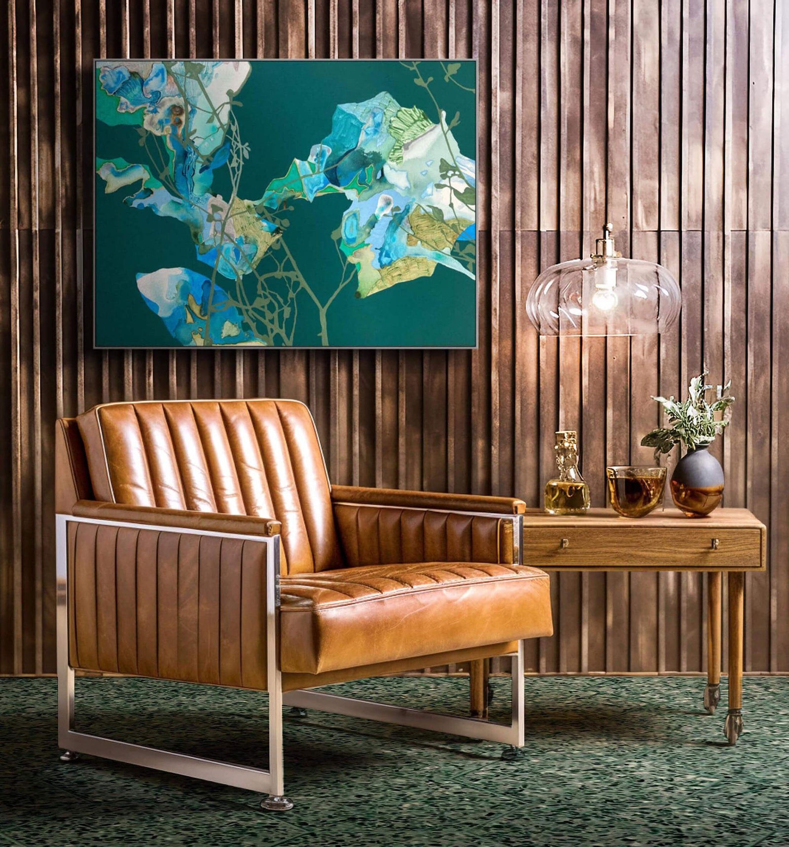 green abstract painting in wood panel room with tan leather vintage modern chair