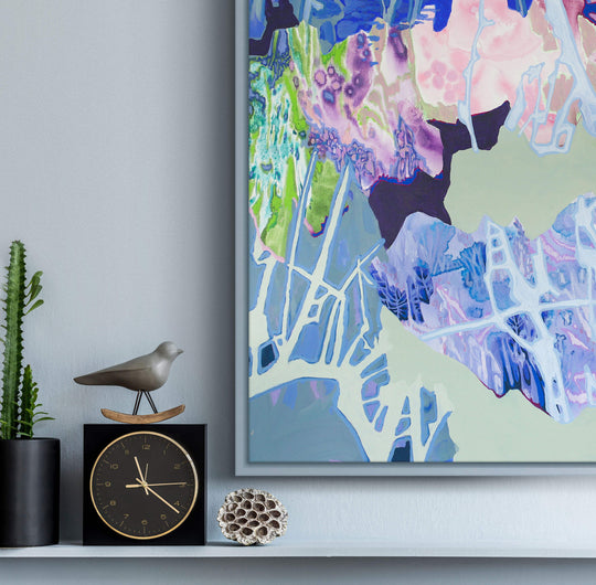 blue and pink abstract painting above a shelf